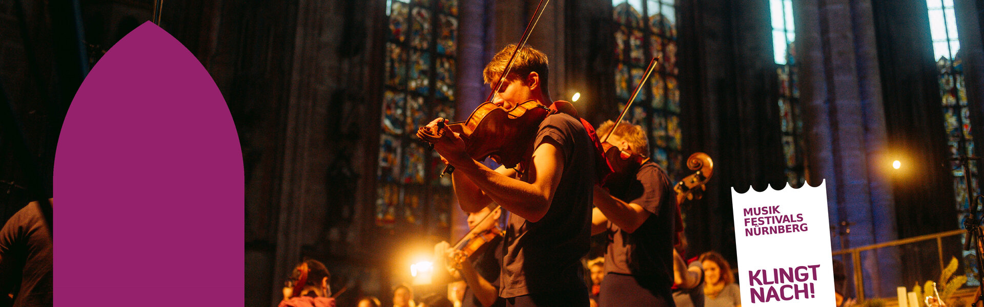 Nahaufnahme eines Geigers bei einem Konzert der Musikfest ION in der Nürnberger Sebalduskirche, im Hintergrund leuchten farbenprächtige gotische Kirchenfenster.