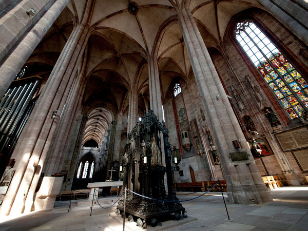 Innenraum der Sebalduskirche Nürnberg mit hohen gotischen Säulen und einem Grab in der Mitte