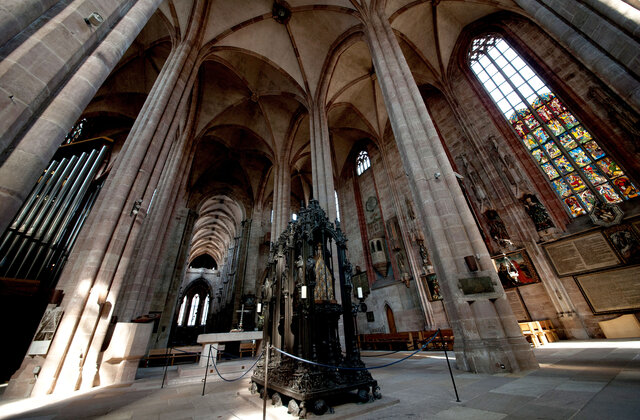 Innenraum der Sebalduskirche Nürnberg mit hohen gotischen Säulen und einem Grab in der Mitte