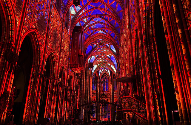 Das innere der Lorenzkirche ist in rotes Licht getaucht. An der Decke sieht es aus, als würde man durch die Verbindungsstreben den Himmmel sehen.