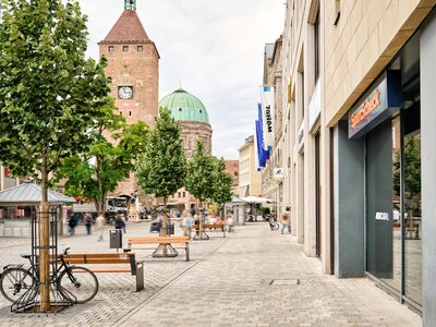 Fußgängerzone mit Bänken, Bäumen und Fahrrad vor Gebäuden am Ludwigsplatz in Nürnberg