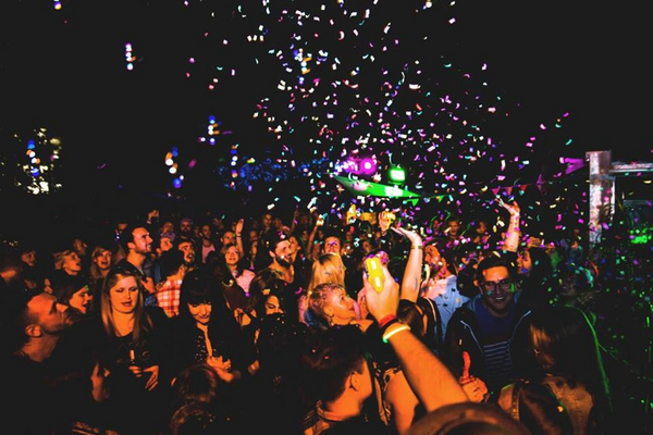 Eine Menschenmenge feiert auf dem Indie Open Air in Nürnberg, umgeben von buntem Konfetti.  