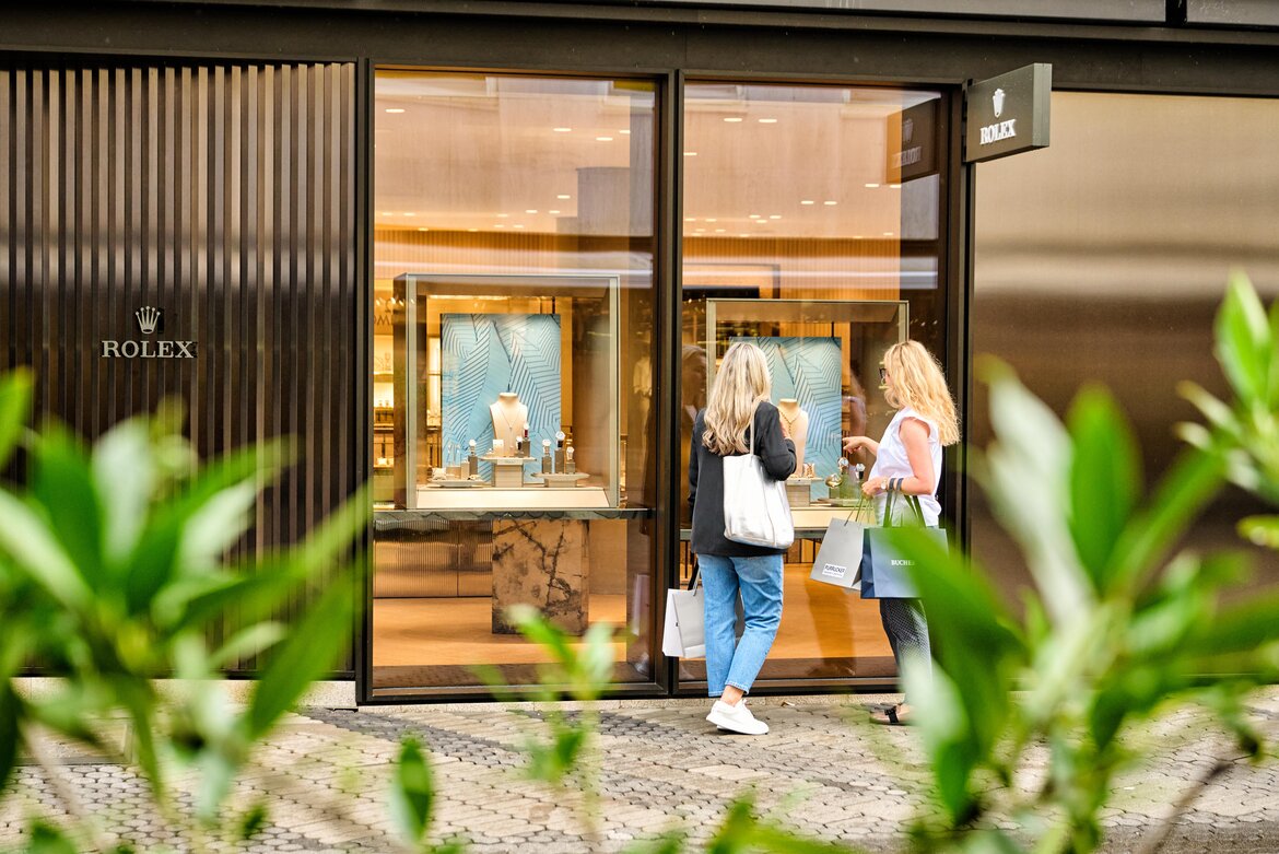 Schaufenster der Rolex-Boutique in der Kaiserstraße Nürnberg mit zwei Frauen, die davor stehen und Einkaufstüten halten