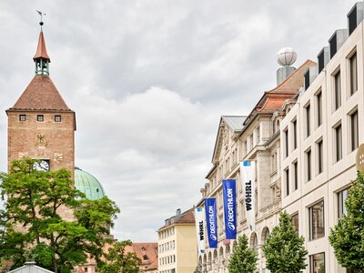 Blick auf den Ludwigsplatz in Nürnberg mit dem Weißen Turm links und dem Wöhrl und Bäumen rechts