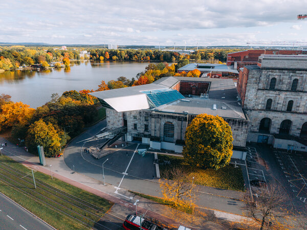 Luftaufnahme des Dokumentationszentrums Reichsparteitagsgelände in Nürnberg mit dem Dutzendteich und herbstlich gefärbtem Baumbestand.