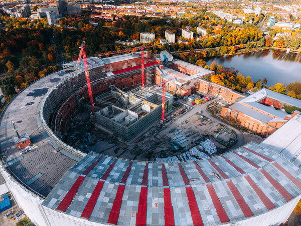 Luftaufnahme der Kongresshalle Nürnberg auf dem ehemaligen Reichsparteitagsgelände mit sichtbarer Baustelle und mehreren Baukränen im Inneren des Gebäudes.