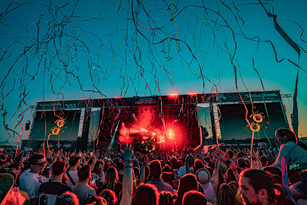 Festivalbesuchende feiern beim Garlic Land Festival am Airport Nürnberg, während Konfetti durch die Luft fliegt.  