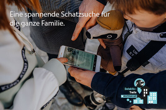 Kinder und Erwachsene halten ein Smartphone mit Text in der Hand, ein Kind trägt einen Teddybär, im Bildtext steht 'Eine spannende Schatzsuche für die ganze Familie', unten rechts das Logo von Detektiv-Trails Nürnberg mit stilisierten Gebäuden und einer Lupe.