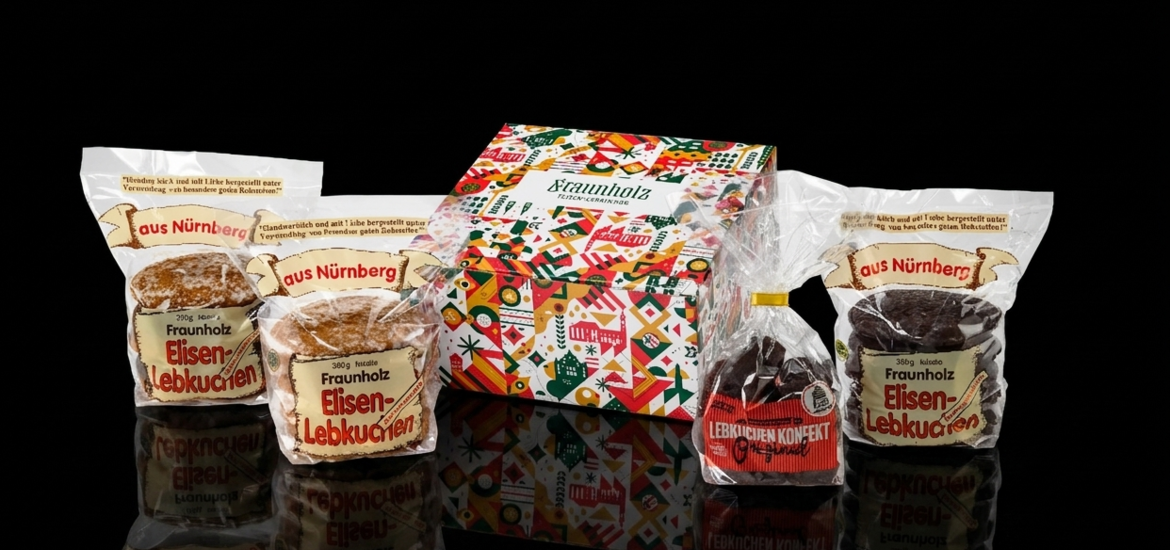 Mehrere Packungen Nürnberger Elisenlebkuchen der Marke Gebr. Fraunholz in unterschiedlichen Verpackungen vor schwarzem Hintergrund