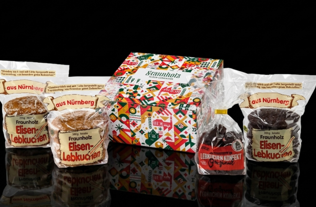Mehrere Packungen Nürnberger Elisenlebkuchen der Marke Gebr. Fraunholz in unterschiedlichen Verpackungen vor schwarzem Hintergrund