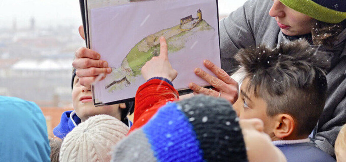 Kinder begutachten eine Handschautafel die der Gästeführer mitgebracht hat.