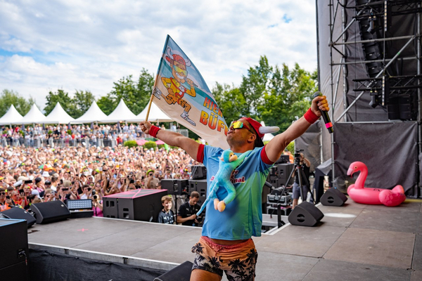  Lorenz Büffel schwenkt eine Flagge vor einer begeisterten Menschenmenge bei der Super Sommer Sause..  