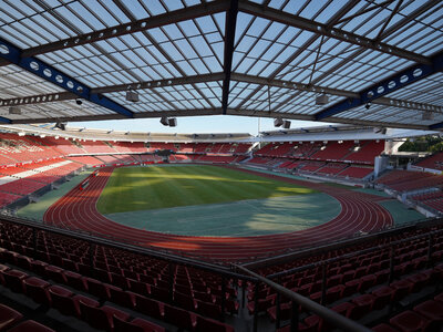 Blick auf das Max-Morlock-Stadion mit grünem Spielfeld und leeren roten Sitzreihen unter einem teilweise offenen Dach
