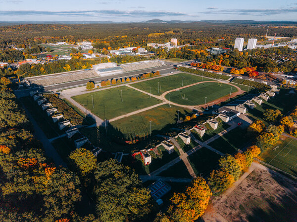 Luftaufnahme des Zeppelinfelds in Nürnberg mit der Tribüne, umgeben von herbstlich gefärbtem Baumbestand.