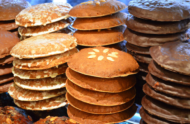 Mehrere Stapel runder Lebkuchen mit unterschiedlichen Glasuren und Dekorationen