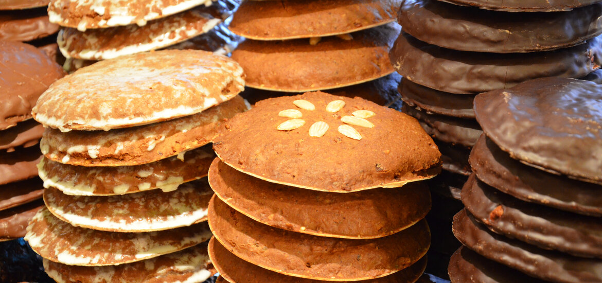 Mehrere Stapel runder Lebkuchen mit unterschiedlichen Glasuren und Dekorationen