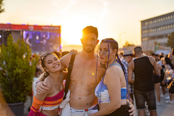 Drei Personen posieren fröhlich für ein Foto beim Latin Airport Festival in Nürnberg.  