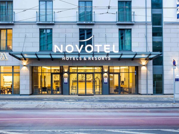 Fassade des Novotel Hotels mit großem Schriftzug und verglaster Eingangstür in einem mehrstöckigen Gebäude