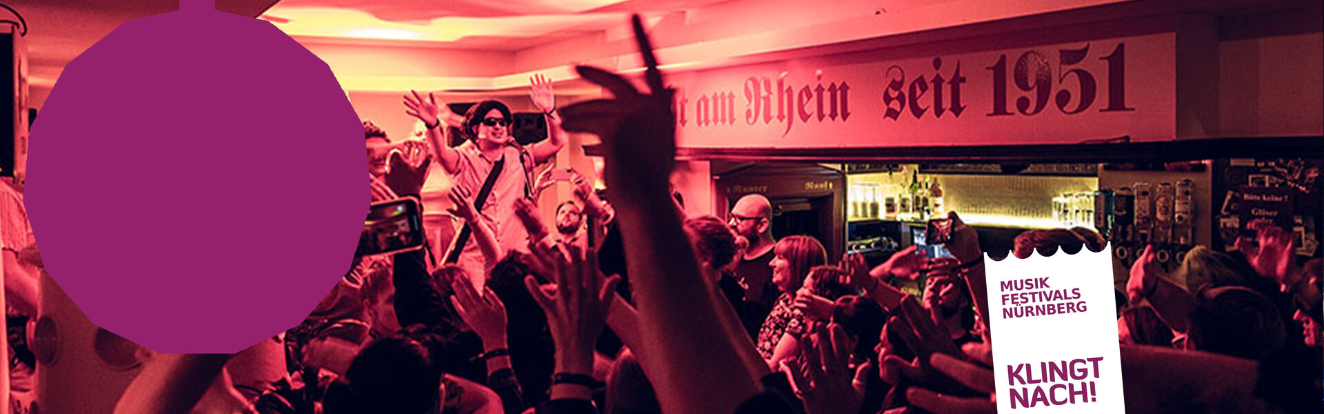 Blick in einen großen, blau beleuchteten Konzertsaal mit einer Discokugel an der Decke. Das Publikum hält hunderte leuchtende Smartphones in die Höhe.