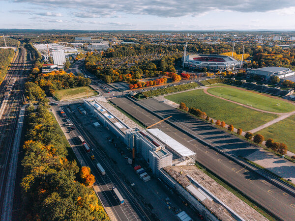 Luftaufnahme des Zeppelinfelds in Nürnberg mit der Tribüne und dem umliegenden Gelände, im Hintergrund das Max-Morlock-Stadion.