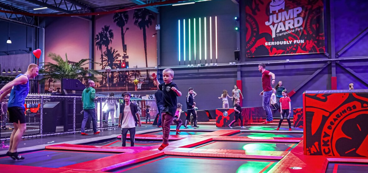Trampolinpark in einer großen Halle mit vielen hüpfenden Kindern und Erwachsenen