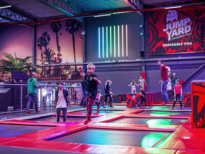 Trampolinpark in einer großen Halle mit vielen hüpfenden Kindern und Erwachsenen