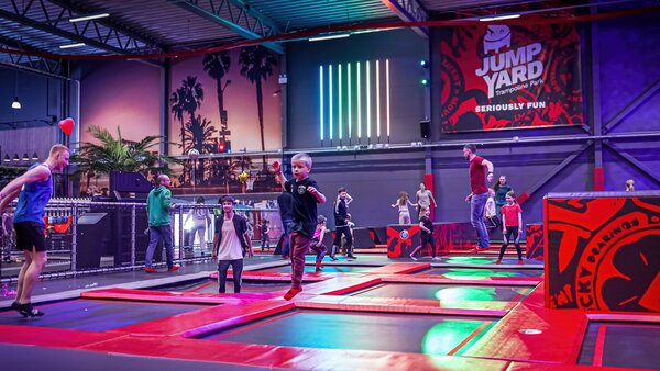 Trampolinpark in einer großen Halle mit vielen hüpfenden Kindern und Erwachsenen