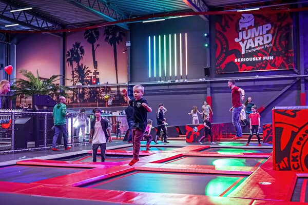 Trampolinpark in einer großen Halle mit vielen hüpfenden Kindern und Erwachsenen